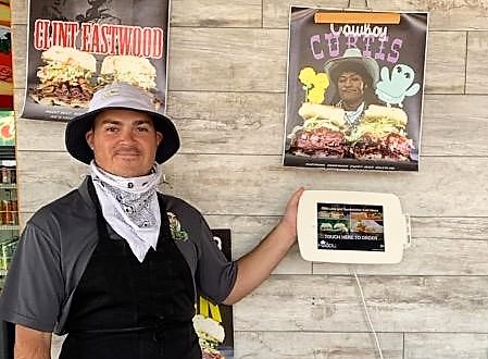 Employee Tucker Bascon directs customers to the Foodli Kiosk